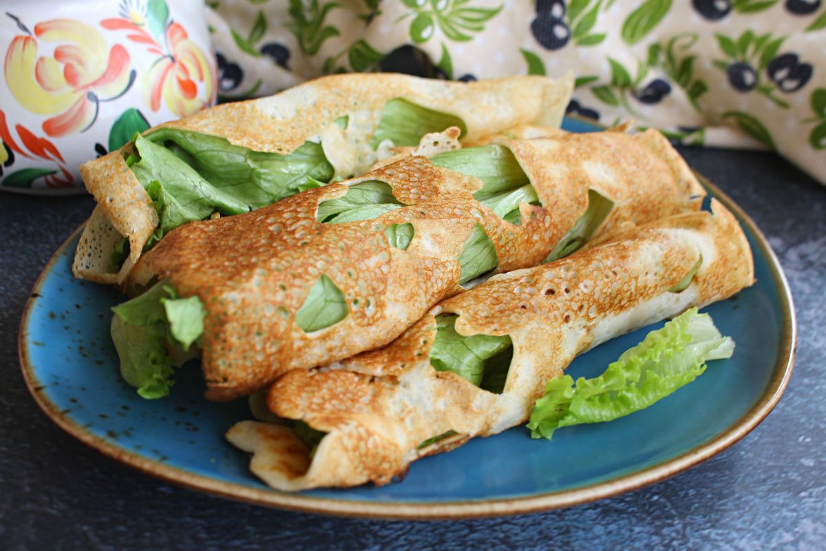 Блины на молоке с листьями салата и красной рыбой